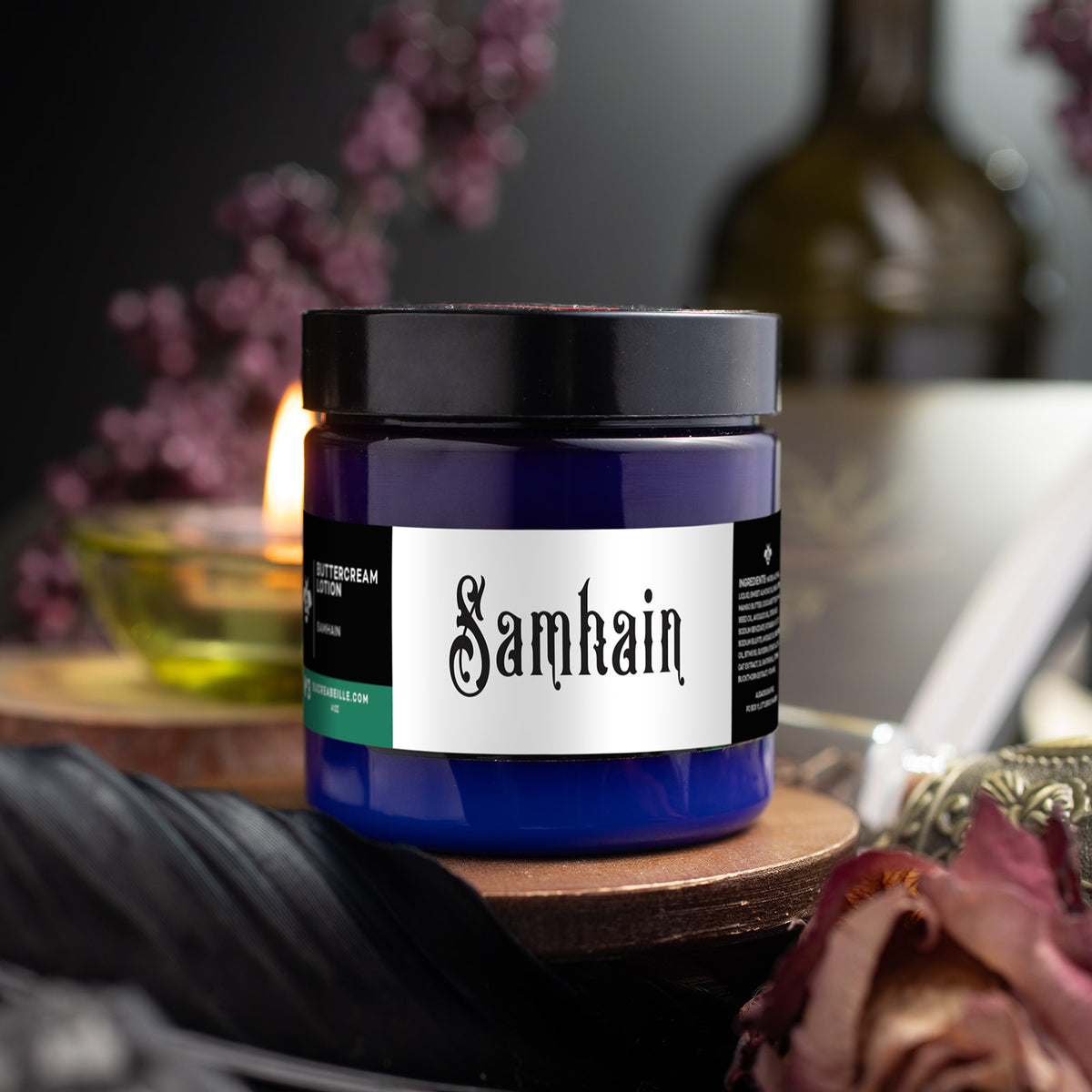 Blue Sucreabeille Samhain buttercream lotion jar with a black lid on a wooden stand.
