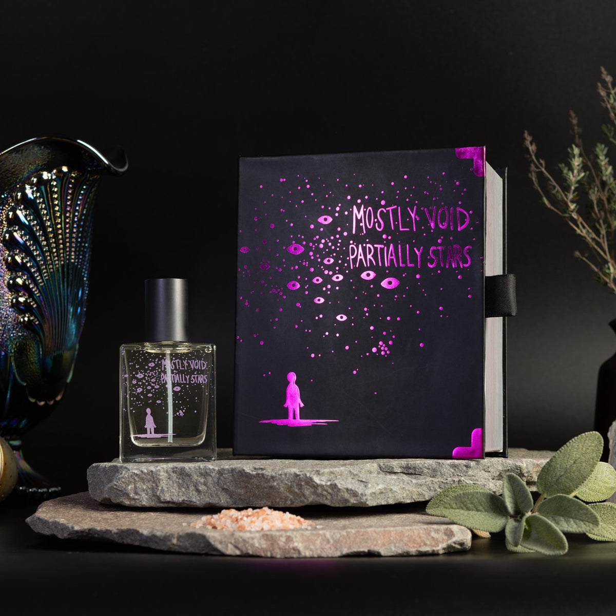 Mostly Void, Partially Stars perfume bottle beside its closed Welcome to Night Vale collector's box.