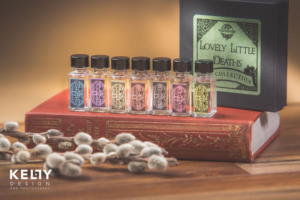 Small perfume bottles in multiple colors on top of a book